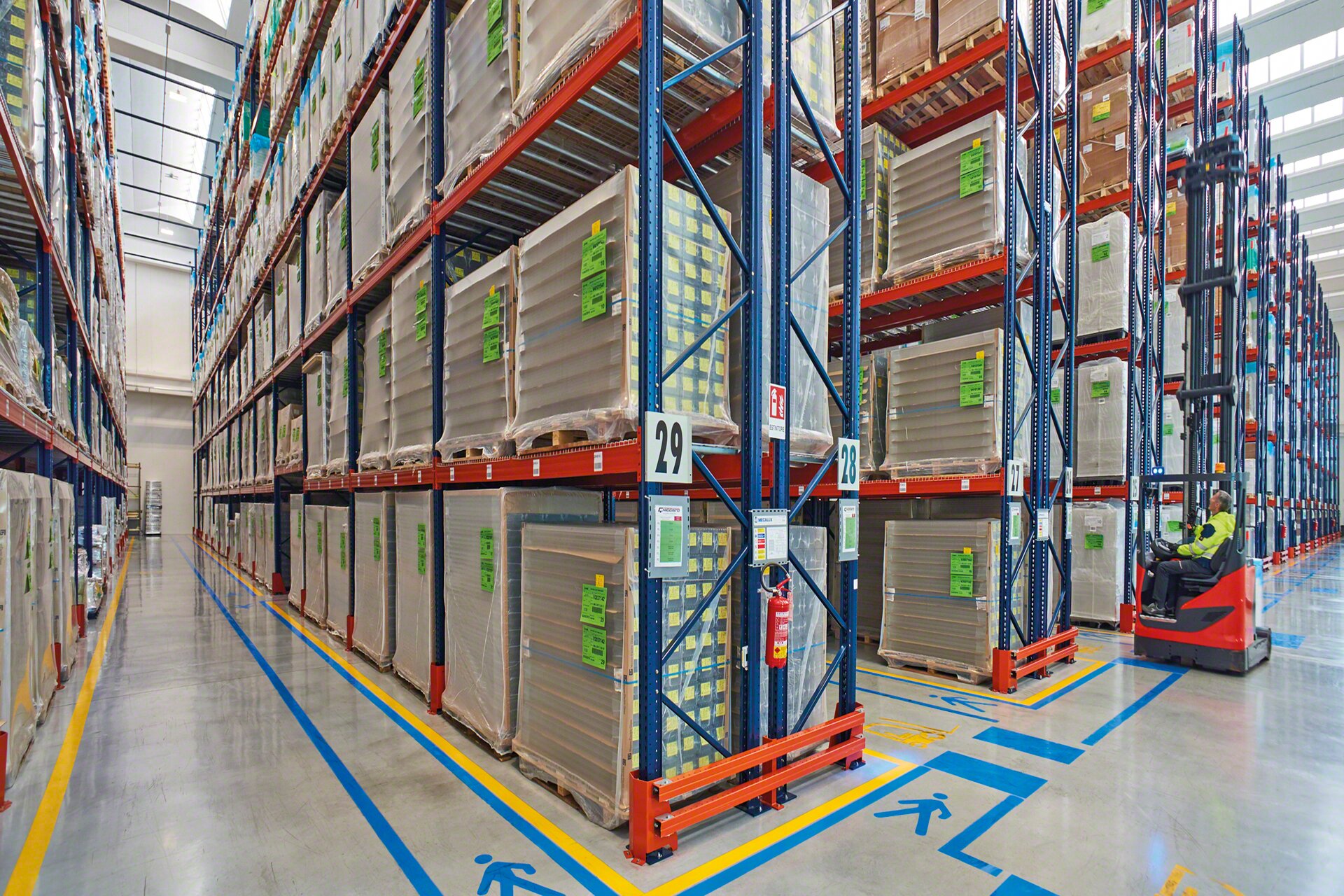La segnaletica orizzontale nei corridoi di lavoro rafforza la sicurezza dell'installazione in un magazzino per pallet